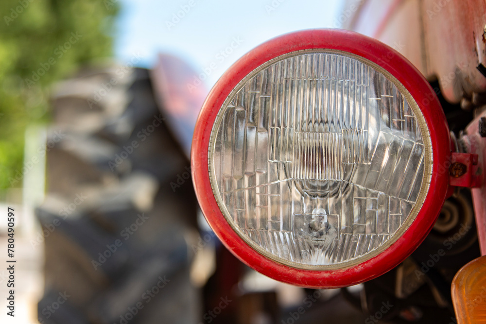 Close-up of the headlight of an old vintage tractor. Detail of the headlight of an old vintage tractor on a sunny day