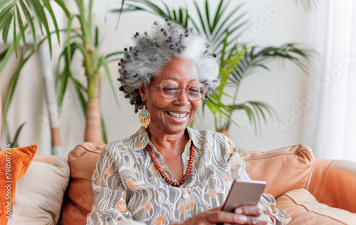 Portrait of a relaxed senior woman smiling using her smartphone at home. Modern lifestyle of the elderly people.