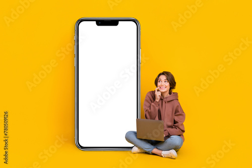 Full length photo of young girl bite finger look empty space board use laptop new it courses discount isolated on yellow color background