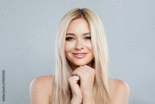 Portrait of young woman blonde with long healthy hair and fresh silky skin posing on white background. Fashion beauty studio portrait