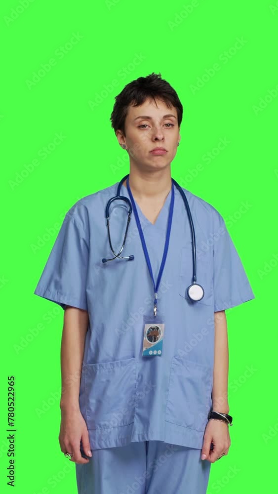 Front view Displeased nurse saying no and sighing against greenscreen backdrop, acting disappointed while she wears blue scrubs. Medical assistant with expertise shows negative gesture, being tired Front view Displeased nurse saying no and sighing against greenscreen backdrop, acting disappointed while she wears blue scrubs. Medical assistant with expertise shows negative gesture, being tired