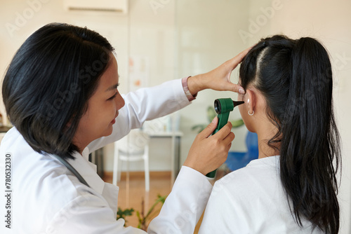 Wallpaper Mural Otolaryngologist examining ears of girl with otoscope Torontodigital.ca