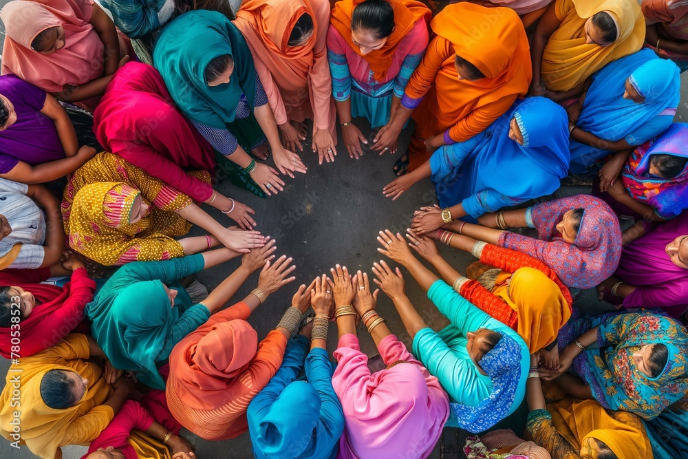 A group of women wearing colorful turbans are holding hands in a circle. Concept of unity and togetherness among the women