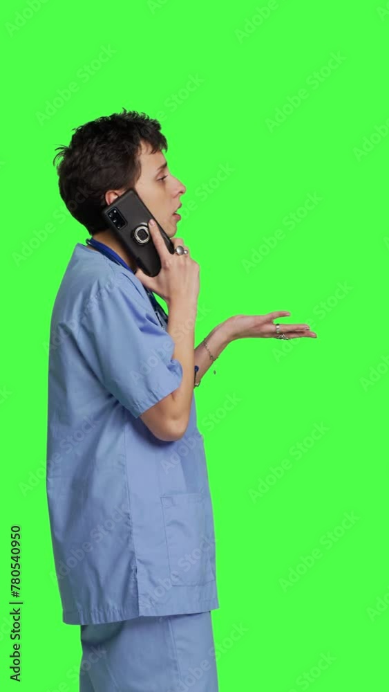 Profile Health specialist using smartphone to make important calls, standing against greenscreen backdrop. Nurse talking to patients for checkup exams on telephone line, calling people to confirm Profile Health specialist using smartphone to make important calls, standing against greenscreen backdrop. Nurse talking to patients for checkup exams on telephone line, calling people to confirm