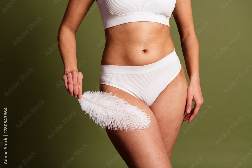 Fototapeta premium No retouch cropped photo of lady tummy underwear lingerie loving herself touching soft featherisolated green color background