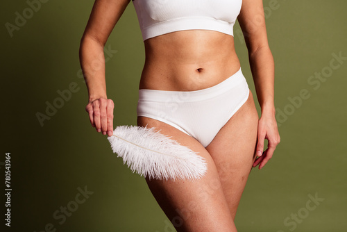 No retouch cropped photo of lady tummy underwear lingerie loving herself touching soft featherisolated green color background © deagreez