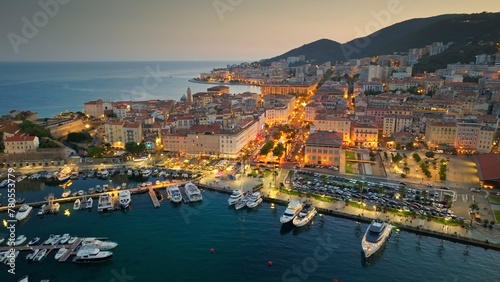 Aerial evening shot of Ajaccio old town, Corsica island. Flying over harbor, old houses and city lights in Ajaccio - capital of Corsica, France