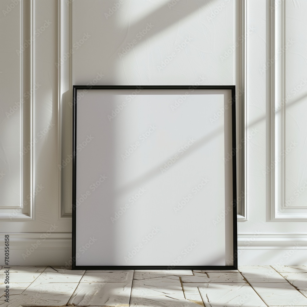 Minimalist empty black-framed square picture frame on a wooden floor against a white paneled wall. Minimalist empty black-framed square picture frame on a wooden floor against a white paneled wall.