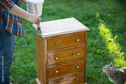 Painting a wooden furniture outdoors, an eco-friendly re-use business. © erika8213