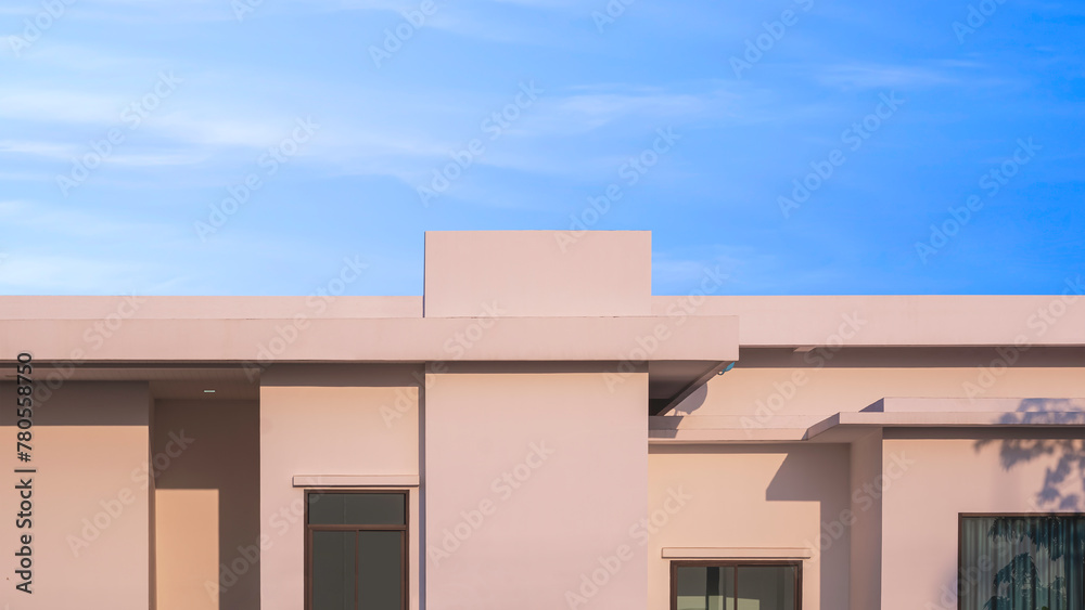 Beige single storey geometric contemporary house against blue sky background