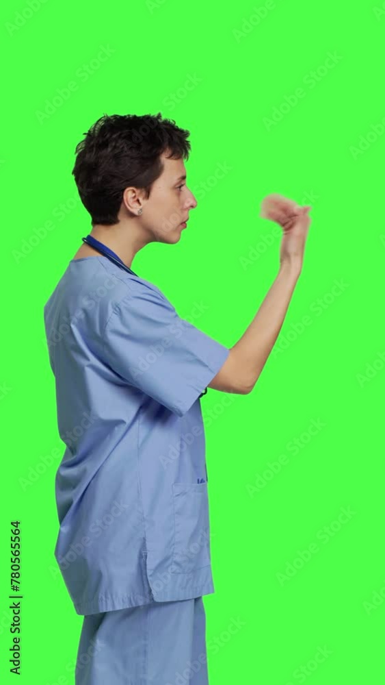 Profile Medical assistant asking a person to come over closer against greenscreen backdrop, inviting patient to approach. Nurse in scrubs calling someone at checkup examination, young surgeon. Camera Profile Medical assistant asking a person to come over closer against greenscreen backdrop, inviting patient to approach. Nurse in scrubs calling someone at checkup examination, young surgeon. Camera