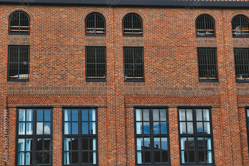 Facade of a vintage brick building with rows of windows reflecting the sky, showcasing industrial architecture in York, North Yorkshire, England. photo