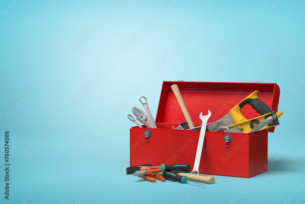 Partially filled toolbox with tools on blue Partially filled toolbox with tools on blue
