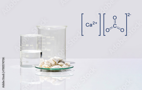 Calcium carbonate chip in chemical watch glass with molecular structure on white laboratory table. Side view photo