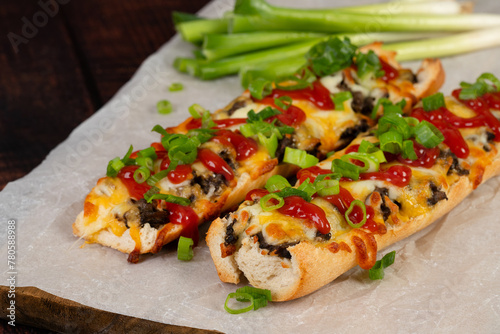 Toasted open-face sandwich made of a sliced baguette  topped with white mushrooms, cheese and ketchup, zapiekanki