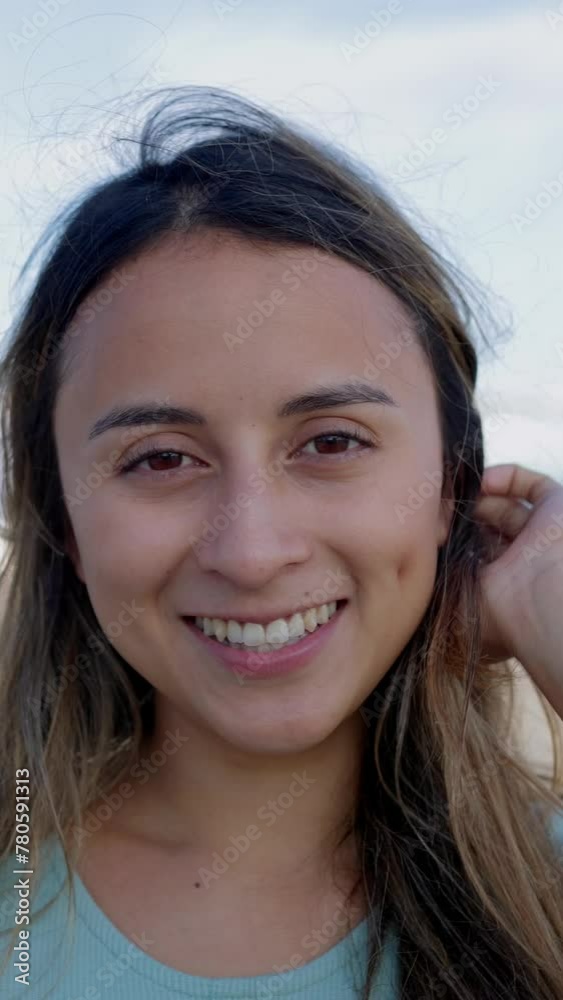 Vertical portrait of cheerful young Latin American beautiful woman looking at camera outdoors. Slow motion footage, positive expression. HD video. Vertical portrait of cheerful young Latin American beautiful woman looking at camera outdoors. Slow motion footage, positive expression. HD video.