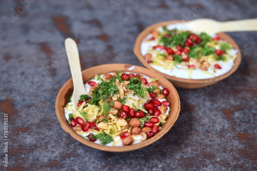 Indian Chaat Dahi Bhalle with Curd and Sweet Sauce on banana leaf with indian backdrop photo