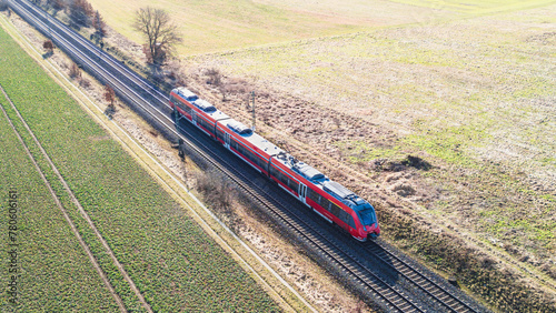 Aerial view of a passenger train driving through the countryside