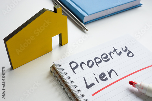 Property lien. Small house and writing in a notebook.