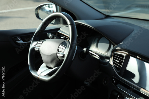 Black steering wheel and dashboard in modern car