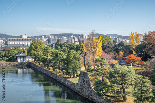Nijo Castle garden and moat in autumn with the modern city in the background, Kyoto, Honshu, Japan photo