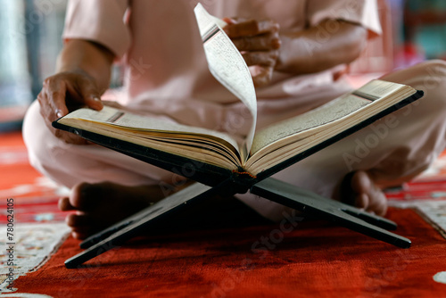 Muslim man sitting reading the Quran (Koran) the holy book of Islam, Mubarak Mosque, Chau Doc, Vietnam, Indochina, Southeast Asia