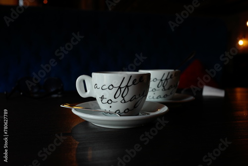 Two white cups of coffee in a cafe, dark room
