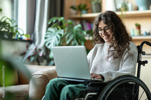 Smiling disability woman in wheelchair work on laptop at home. Technology and lifestyle concept