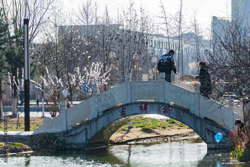 Tangshan City, Hebei Province, China: March 31, 2024- During the spring holiday, people go for a spring outing in a city park with blooming flowers photo