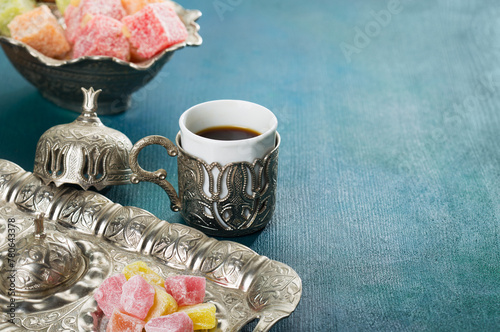 Traditional turkish coffee and turkish delight on  blue-green wooden background