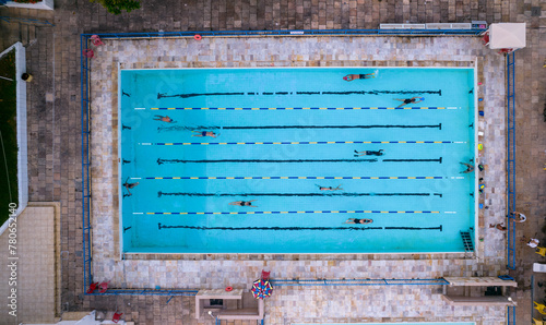 Several people training and exercising in a swimming pool while others watch