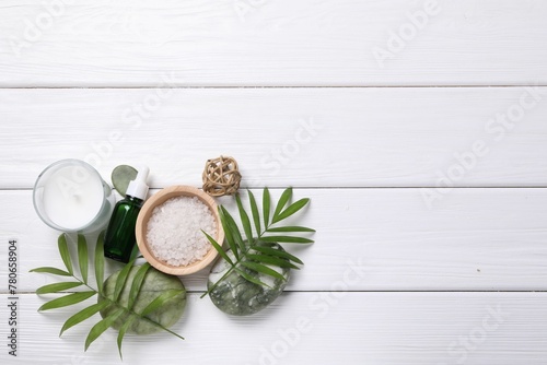 Flat lay composition with candle and different spa products on white wooden table. Space for text