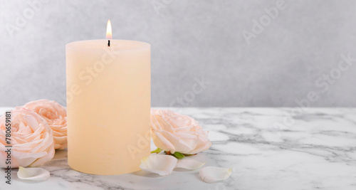 Spa composition with burning candle and flowers on white marble table  space for text