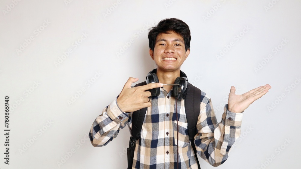 happy young asian man posing pointing at his palm with an isolated white background happy young asian man posing pointing at his palm with an isolated white background