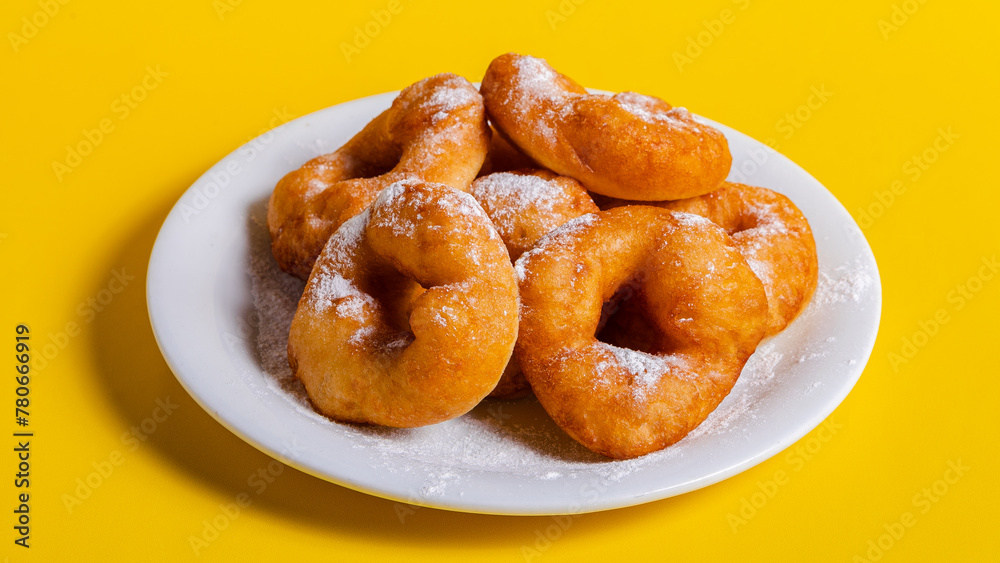 Fried donuts on plate isolated on yellow Fried donuts on plate isolated on yellow