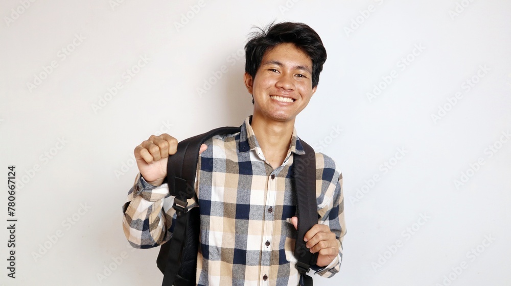 happy young asian man posing raising his hands enthusiastically and holding a bag on an isolated white background happy young asian man posing raising his hands enthusiastically and holding a bag on an isolated white background