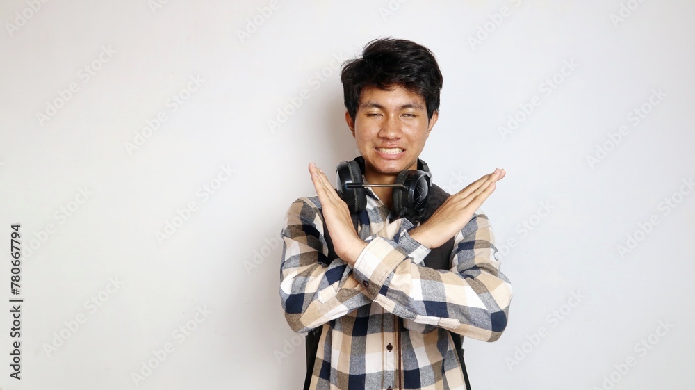 Young Asian man holding a bag is posing with crossed arms, stop, no Young Asian man holding a bag is posing with crossed arms, stop, no