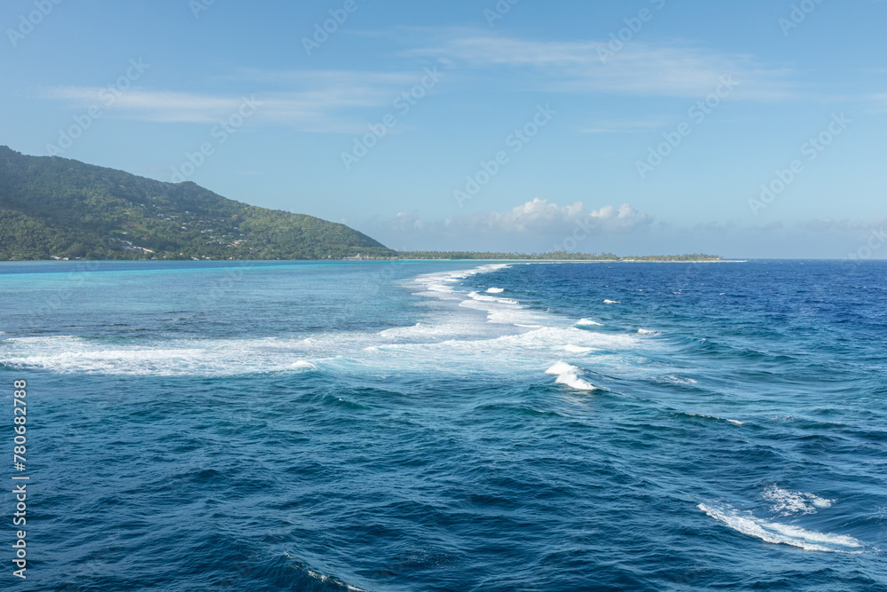 Surf breaks over the coral reef separating the shallow turquoise waters of the lagoon surrounding the lush South Pacific island of Mo'orea, French Polynesia, from the blue water of the Pacific Ocean. Surf breaks over the coral reef separating the shallow turquoise waters of the lagoon surrounding the lush South Pacific island of Mo'orea, French Polynesia, from the blue water of the Pacific Ocean.