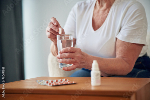 Self medicate. Taking medicine. Senior elderly woman is at home in the living room