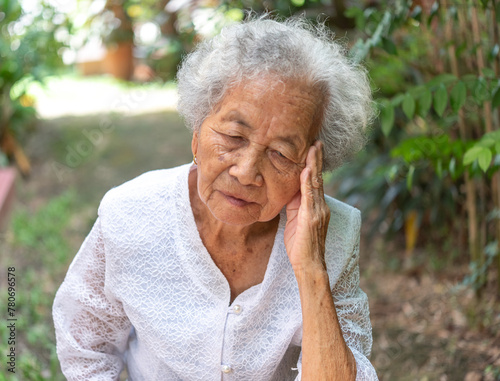 Sad senior old woman. Lonely from loss or sick with headache. Upset patient in retirement home with stress or pain.