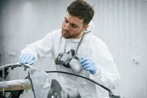 Unfinished part. Repairman is working with carcass of the car in the garage