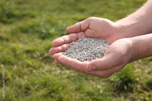 Man with fertilizer in hands outdoors, closeup © New Africa