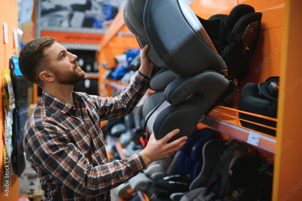 young male with car seat for kids in the children's store