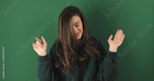Brunette woman looking camera pointing fingers herself ask me no i do not need it. Girl point on her, waving her hands and say no isolated on green background. photo