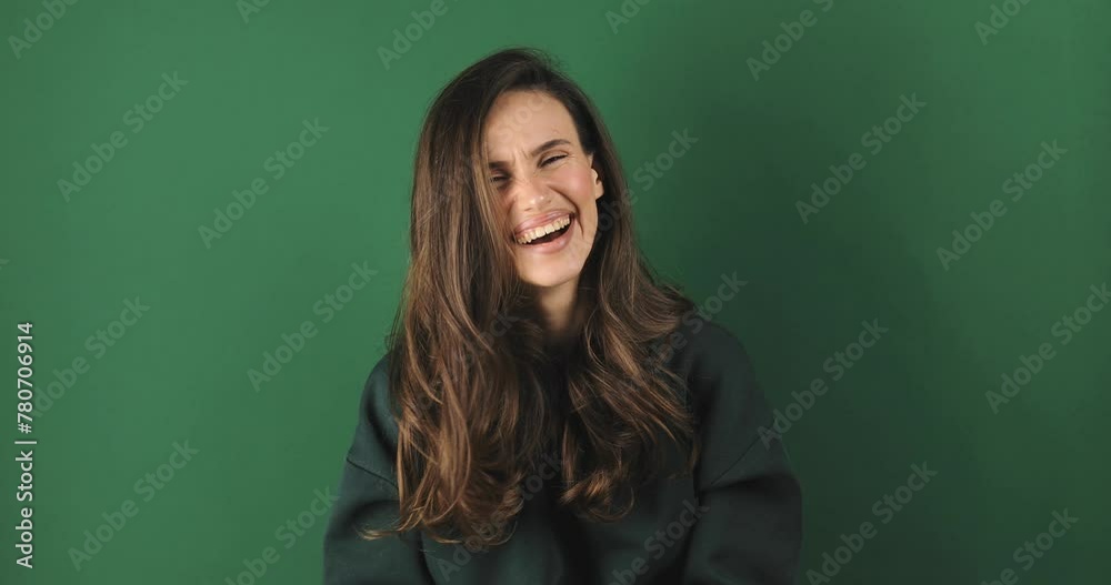 Happy joyful young brunette curly woman wear green sweatshirt laughing, smiling, she look excited, standing on green background. Happy joyful young brunette curly woman wear green sweatshirt laughing, smiling, she look excited, standing on green background.