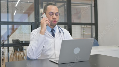 Hispanic Doctor Talking on phone in Clinic photo