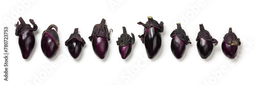 Fresh purple mini eggplants in a row isolated on white background close up