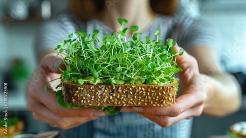 A woman holds a sandwich with plantbased microgreen sprouts as the main ingredient photo
