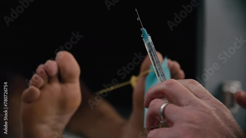 Syringe in front of a morgue corpse with doctor photo