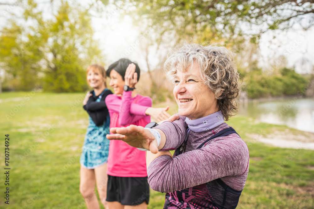 Joyful senior stretching, women sharing a light-hearted moment during a fitness routine in the park. Healthy lifestyle concept for mature women Joyful senior stretching, women sharing a light-hearted moment during a fitness routine in the park. Healthy lifestyle concept for mature women